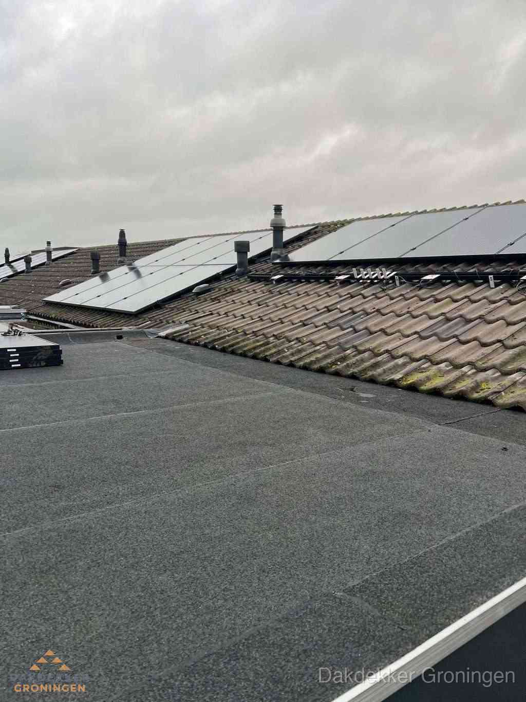 Plat dak inspectie met bitumen bedekking naast schuin pannendak in Groningen Plat dak inspectie met bitumen bedekking naast schuin pannendak in Groningen