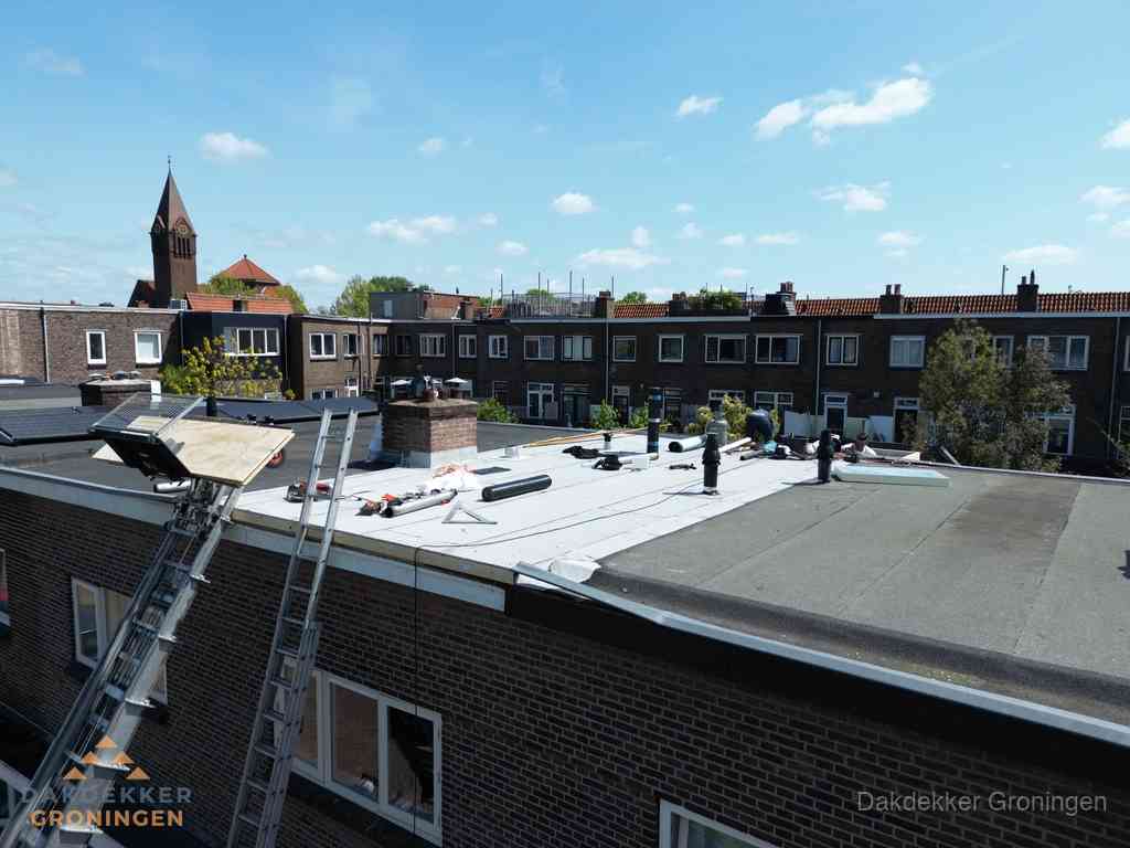 Dakdekkers aan het werk op plat dak in Groningen Dakdekkers aan het werk op plat dak in Groningen