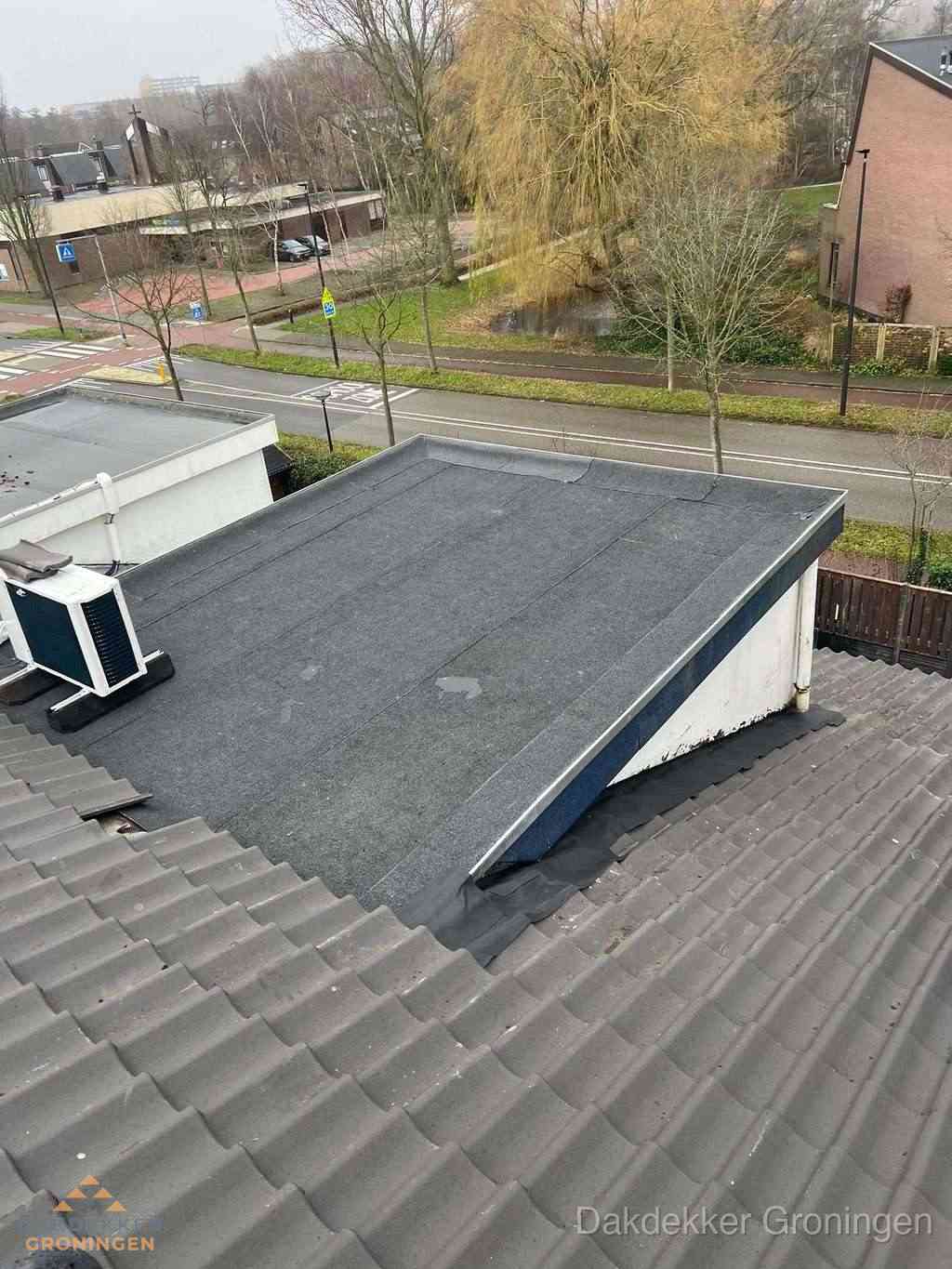 Plat dak met bitumen dakbedekking naast schuin pannendak in Groningen Plat dak met bitumen dakbedekking naast schuin pannendak in Groningen