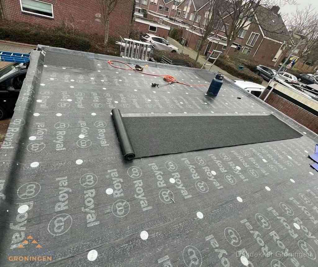 Dakdekker aan het werk met gasbrander op plat bitumen dak in Groningen Dakdekker aan het werk met gasbrander op plat bitumen dak in Groningen
